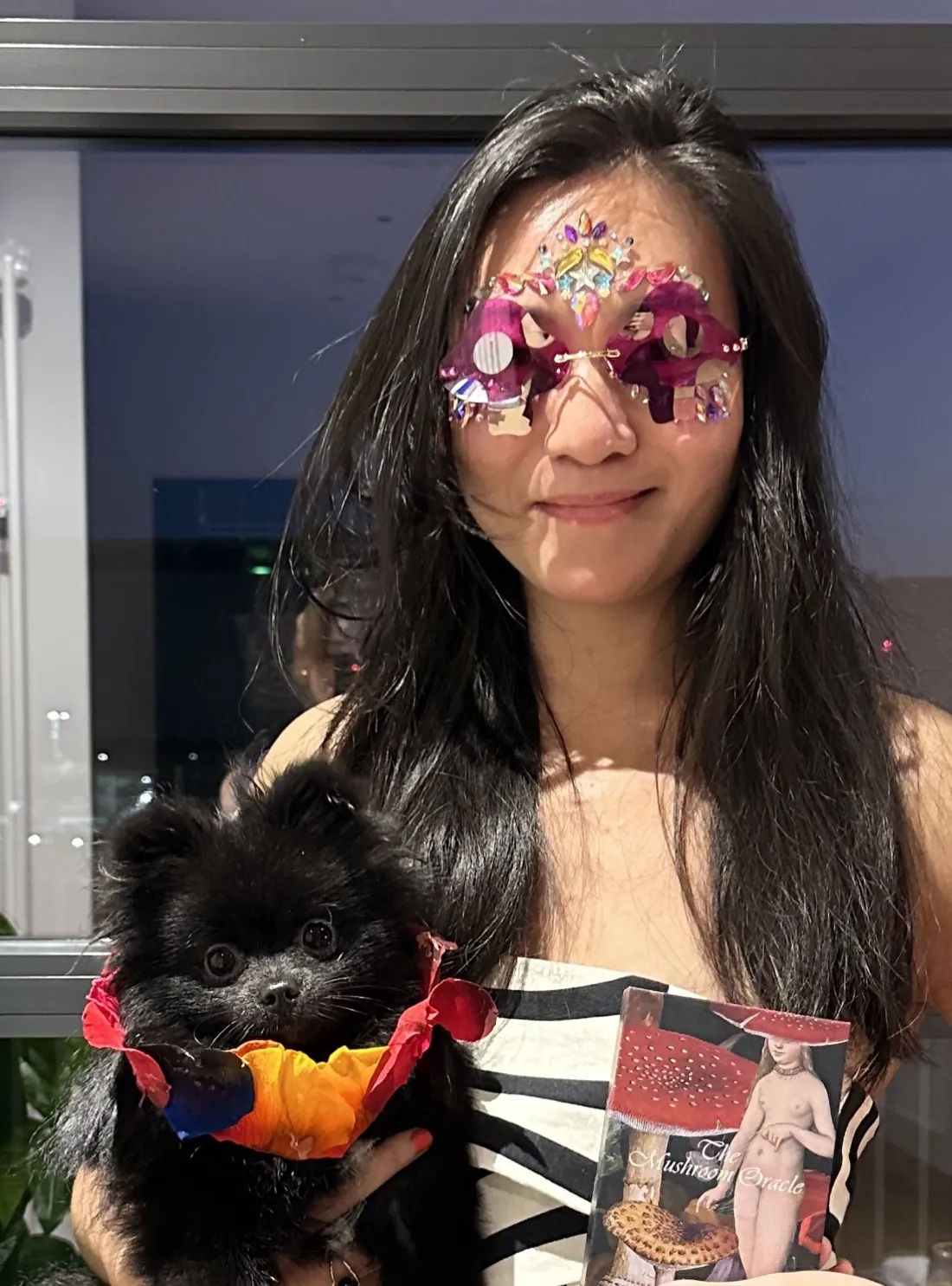 Ginny Wan in jewelled glasses holding her dog